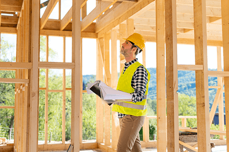 Engineer Hardhat Blueprints On Building Site