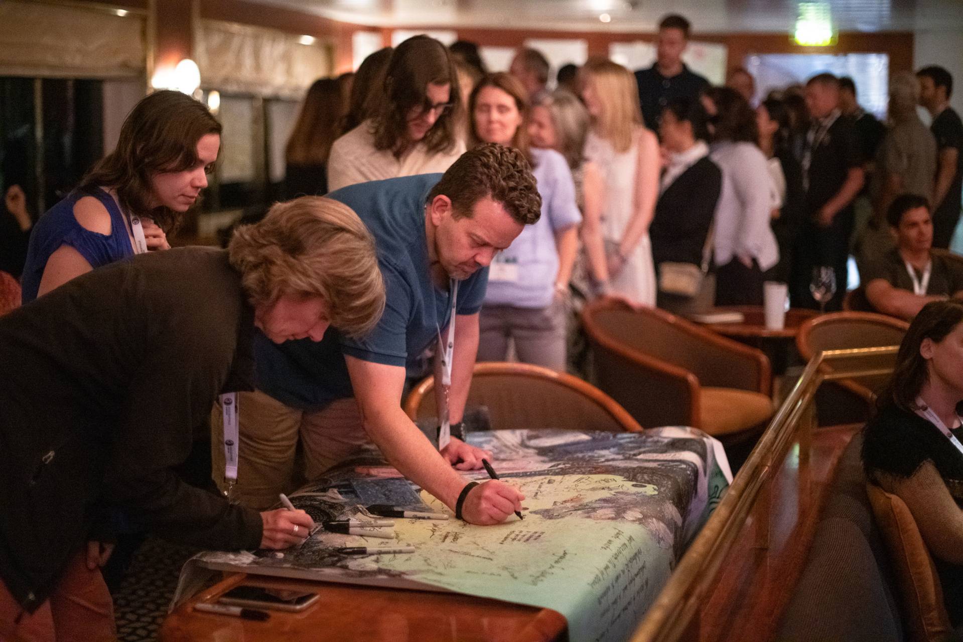 Keith Christman signing poster at a conference